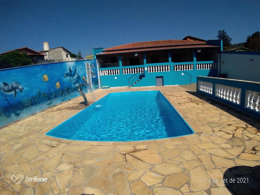 une grande piscine bleue devant un immeuble dans l'établissement Chácara Oliveira, à Socorro