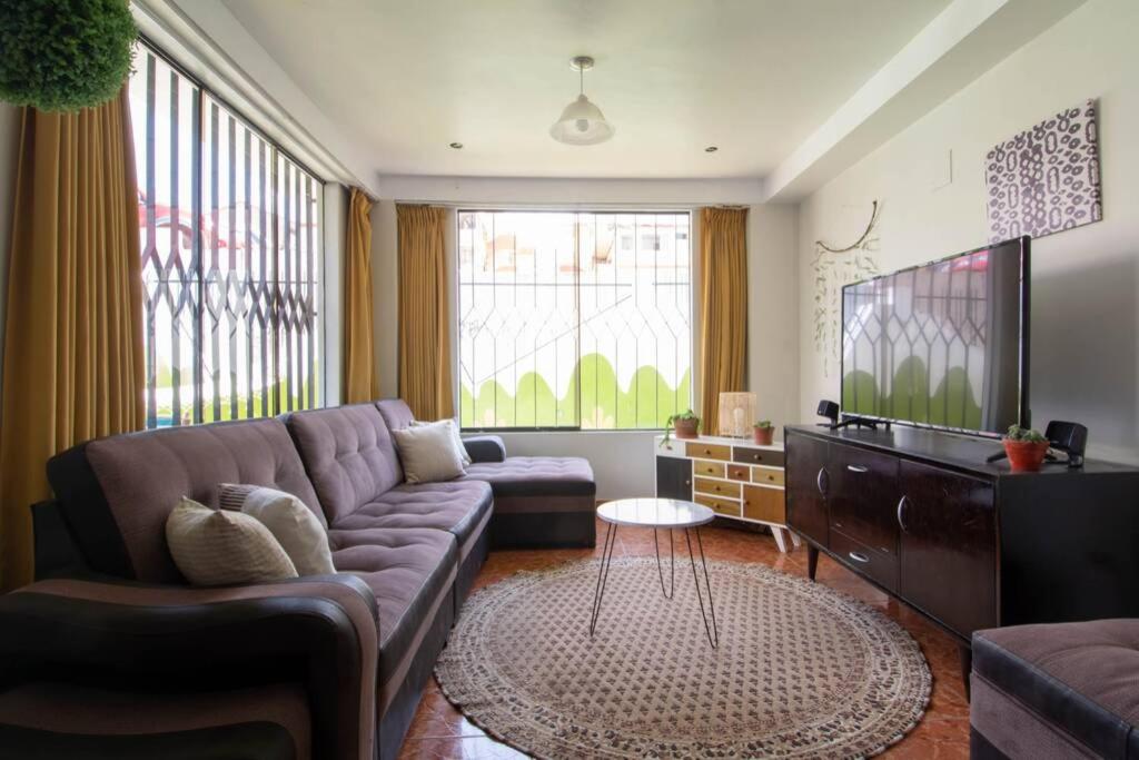 a living room with a couch and a tv at Sunny 6 bedroom house with private garden & rooftop in Cusco