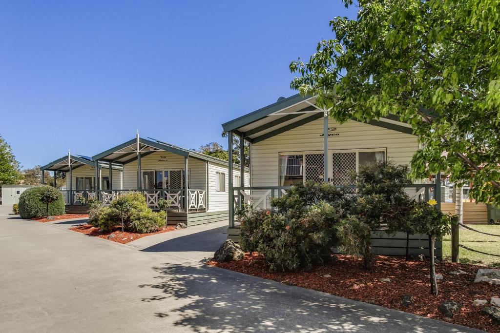 a house with trees and bushes in front of it at Paynesville Holiday Park in Paynesville