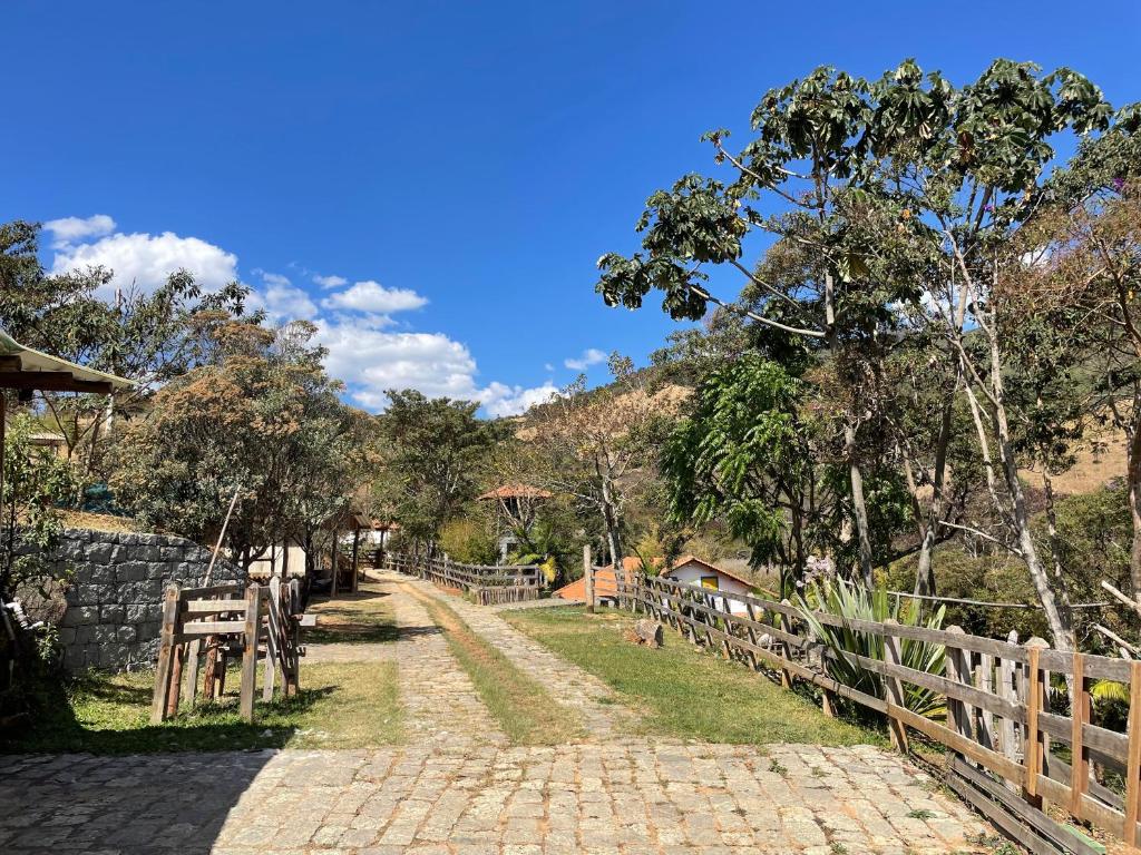 eine Kopfsteinpflasterstraße mit einem Zaun und einem Berg in der Unterkunft Casa Amarela in Passa Quatro