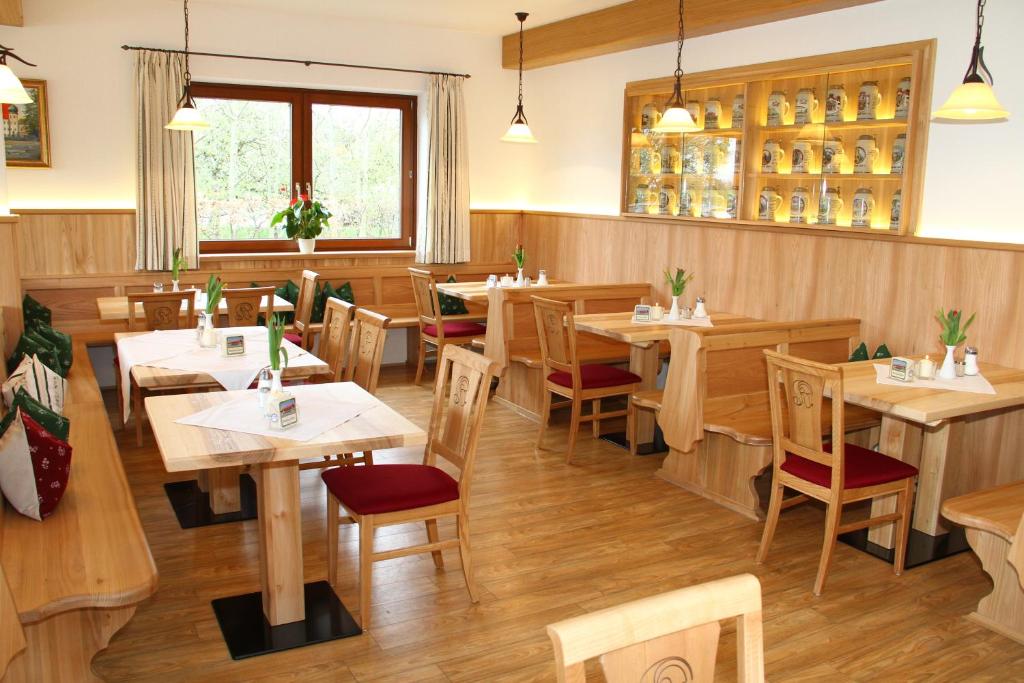 una sala da pranzo con tavoli e sedie in legno di Hotel-Gasthof Kramerwirt a Irschenberg