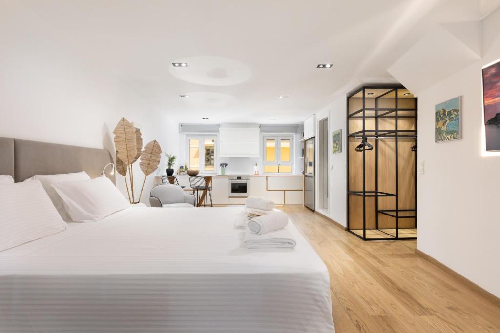 a bedroom with a large white bed and a living room at Scalinada Luxury Suites in Corfu Town