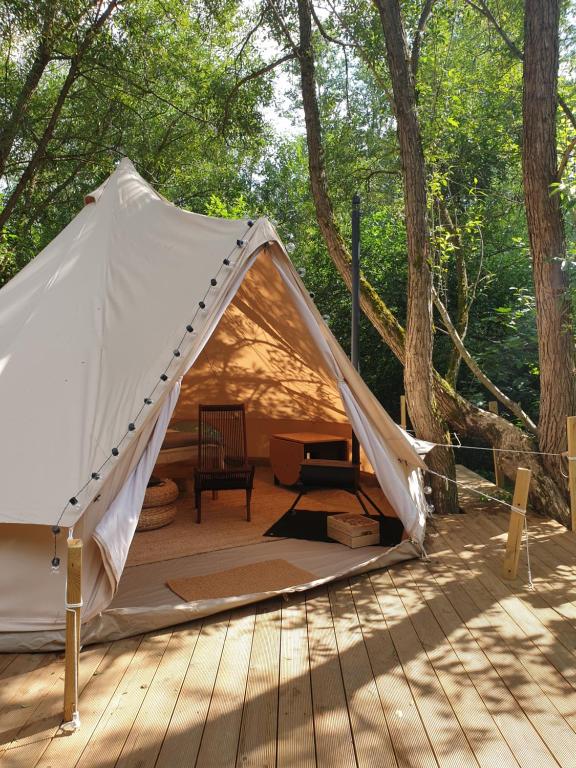 Stovyklavietė TekaTeka في أنيكشيالي: خيمة بيضاء على سطح خشبي به أشجار