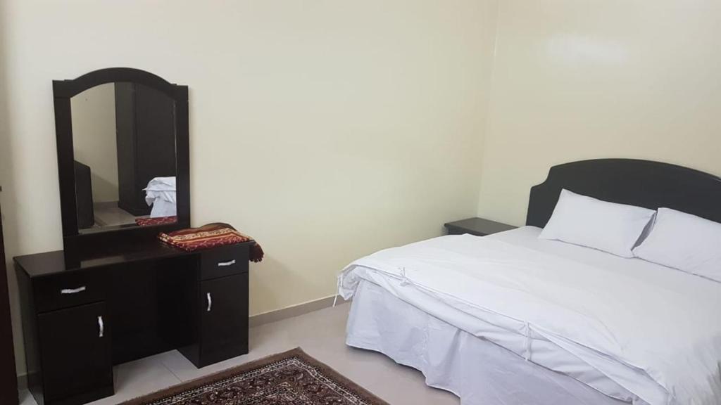 a bedroom with a bed and a dresser with a mirror at العييري للشقق المفروشة حائل1 in Hail