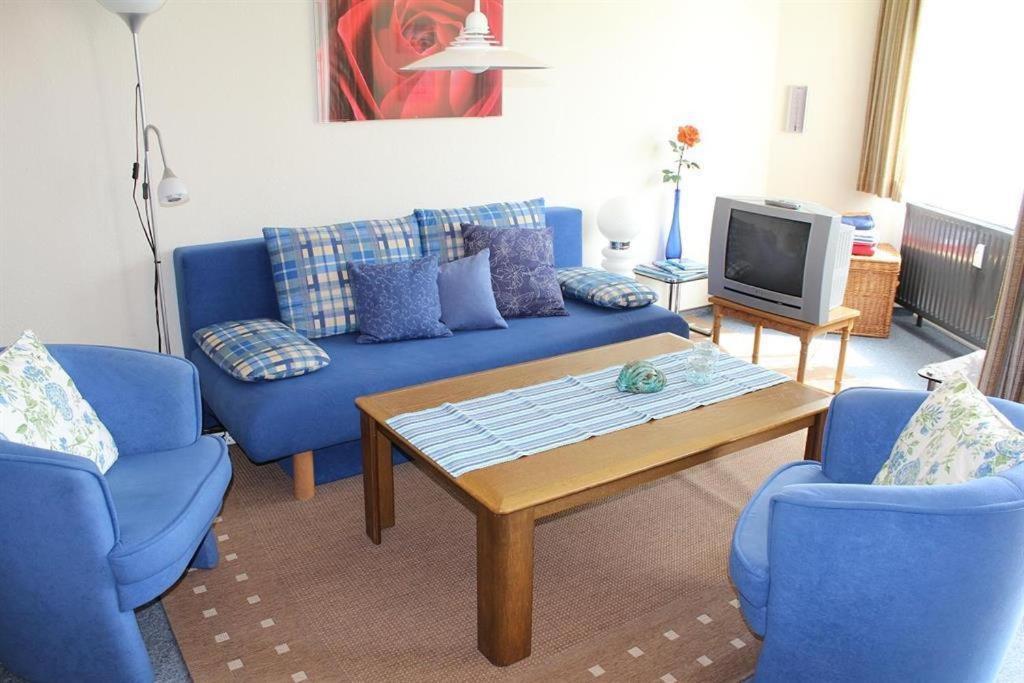 een woonkamer met een blauwe bank en twee blauwe stoelen bij Appartement 1 Haus Residenz in Sankt Peter-Ording