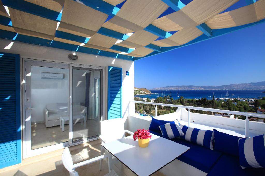a balcony with blue and white furniture and a view of the ocean at Bellazure Hotel in Akyarlar