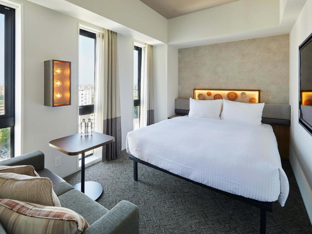 a hotel room with a bed and a couch at Susukino Granbell Hotel in Sapporo