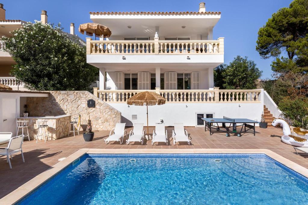 a villa with a swimming pool and a house at Villa Felicidad in Font de Sa Cala