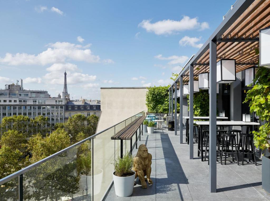 a dog sitting on a balcony with a view of the eiffel tower at citizenM Paris Champs-Élysées in Paris
