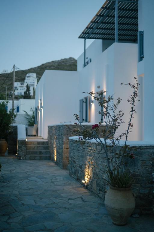 a building with a stone wall and a vase with a plant at Indigo Studios in Livadi