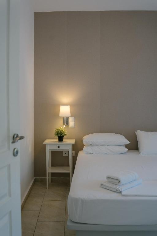 a bedroom with two beds and a table with a lamp at Indigo Studios in Livadi