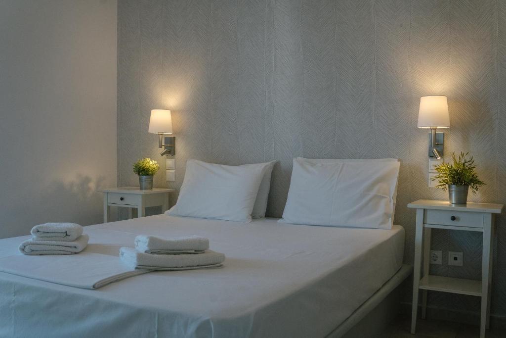 a bed with white pillows and towels on it at Indigo Studios in Livadi
