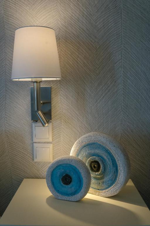a lamp sitting on a table next to a wall at Indigo Studios in Livadi