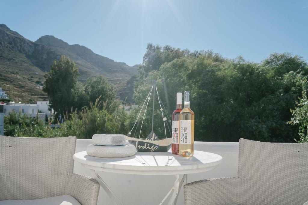 a bottle of wine sitting on a table with two chairs at Indigo Studios in Livadi