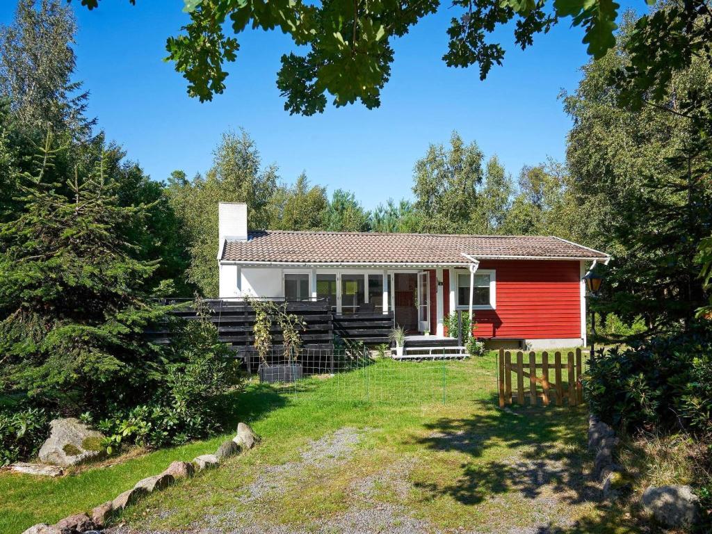 a red house in the middle of a yard at 4 person holiday home in Aakirkeby in Vester Sømarken