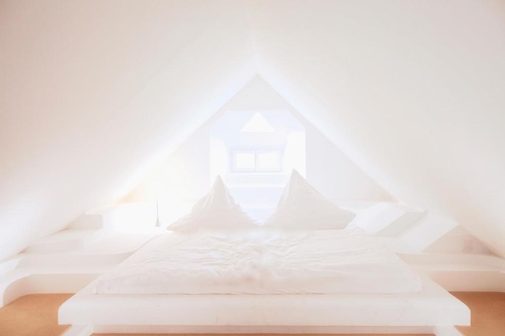 a white bed in a room with a window at Denkmalschmiede Höfgen in Grimma