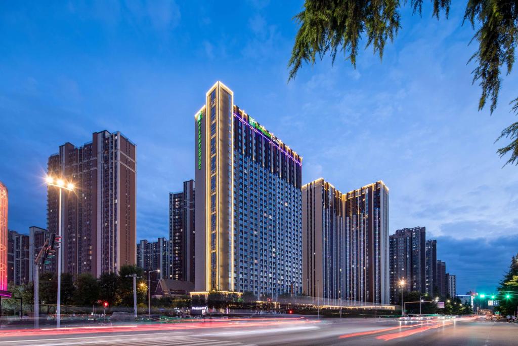 un edificio alto en una ciudad por la noche en Holiday Inn Express Xi'an High Tech South, an IHG Hotel, en Xi'an