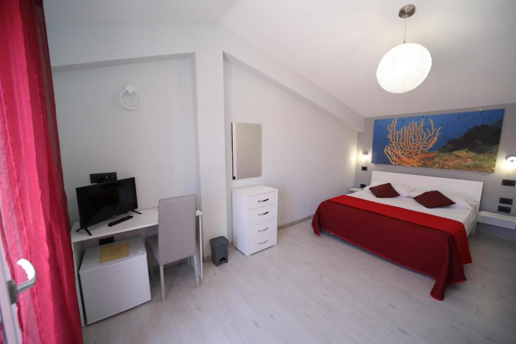 a bedroom with a bed and a desk with a computer at IsolaDino b&b sweet home in Praia a Mare