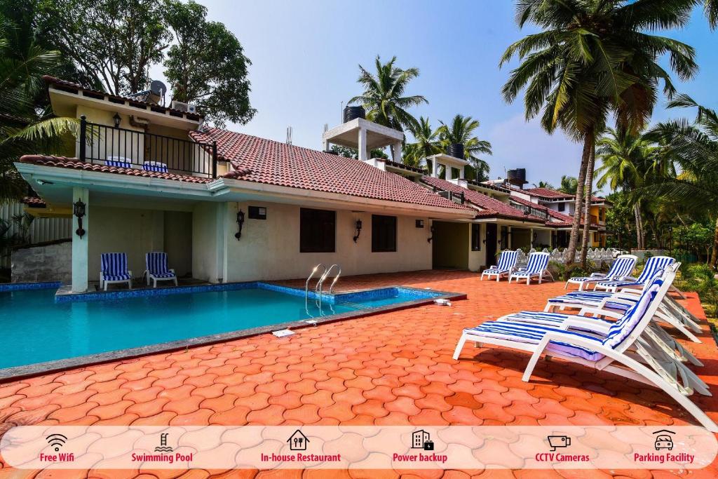 a resort with a swimming pool and lounge chairs at Meadow View Resort in Majorda