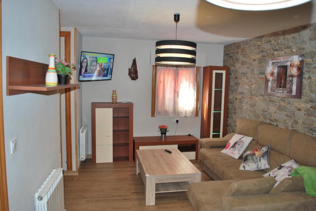 ein Wohnzimmer mit einem Sofa und einem Tisch in der Unterkunft Apartamento Rural Lago Ercina in Cangas de Onís