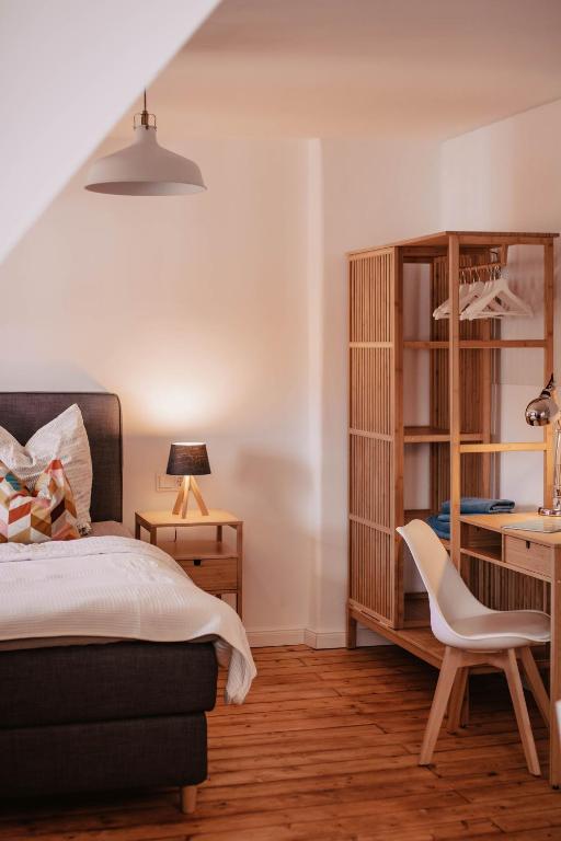 a bedroom with a bed and a desk and a chair at Apartment 25 - zentrumsnah - Parkplatz in Coburg