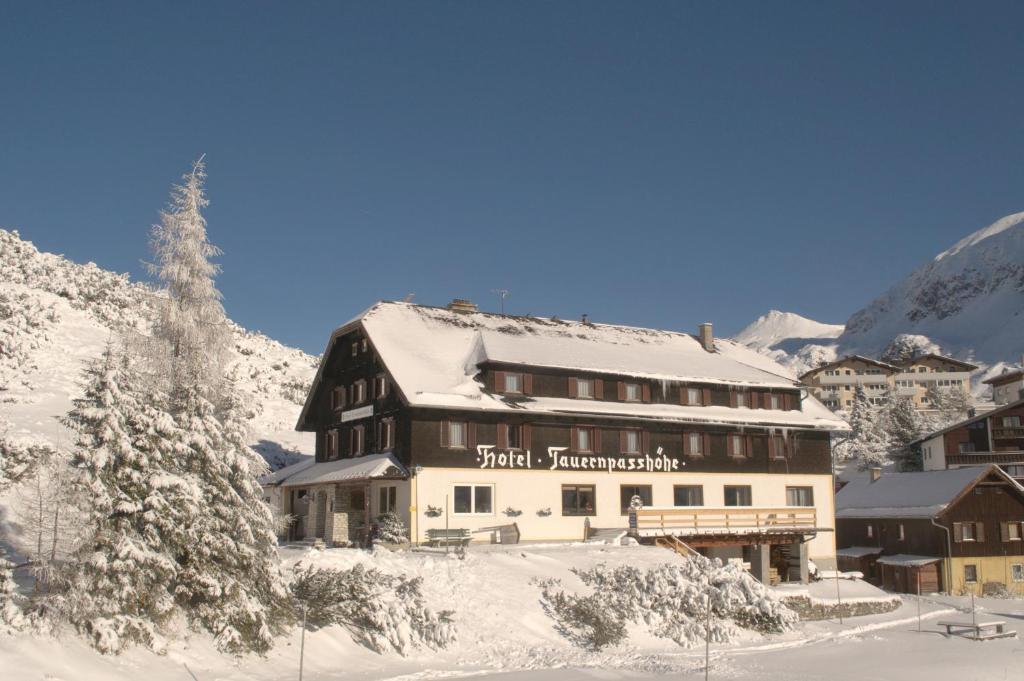 duży budynek z śniegiem na nim w górach w obiekcie Hotel Tauernpasshöhe w mieście Obertauern