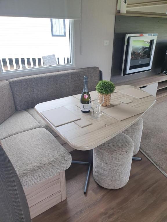 a table with a bottle of wine and two chairs at Seton Sands Holiday Home in Port Seton