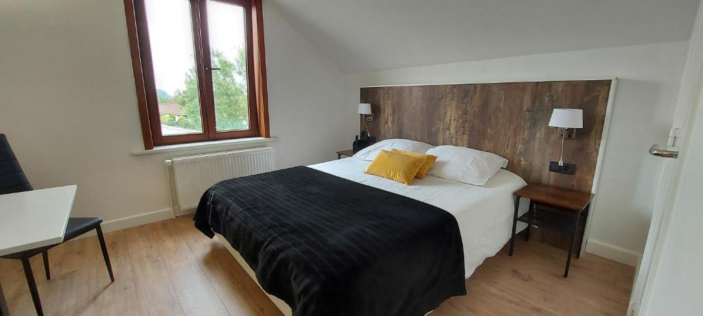 Schlafzimmer mit einem großen Bett mit einem Kopfteil aus Holz in der Unterkunft Hotel La Cascada in Bredene