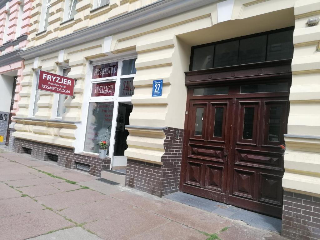a store with a brown door on a building at Hostel Tulip - Pokój 4 ze wspólną łazienką i kuchnią in Szczecin