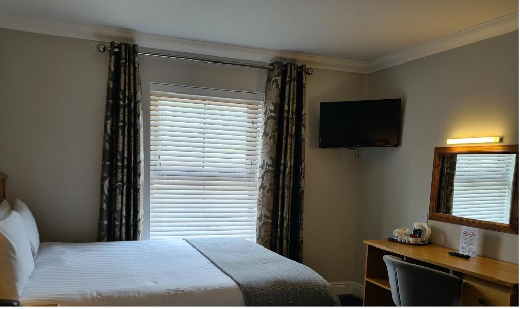a hotel room with a bed and a window at Caisleain Oir Hotel in Annagry