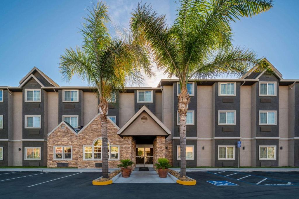 a large building with palm trees in a parking lot at Microtel Inn & Suites by Wyndham Tracy in Tracy