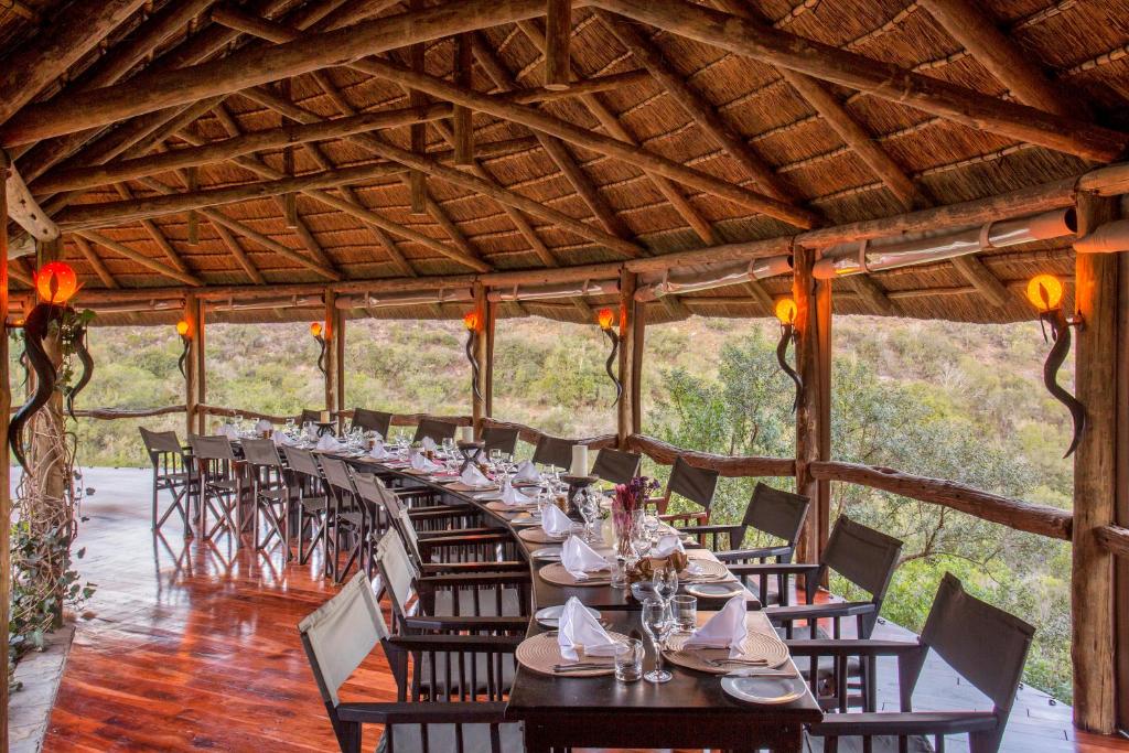 uma longa sala de jantar com uma longa mesa com cadeiras em Lalibela Game Reserve Lentaba Safari Lodge em Paterson