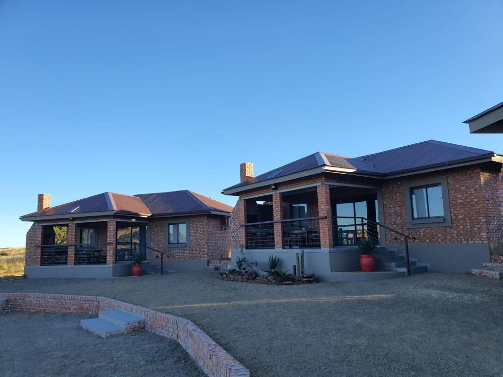 een groot bakstenen huis met een oprit ervoor bij Goedehoop Game Farm in Bloemfontein