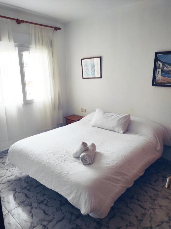a bedroom with a white bed with two towels on it at Marina Sunrise Puerto in Torrevieja