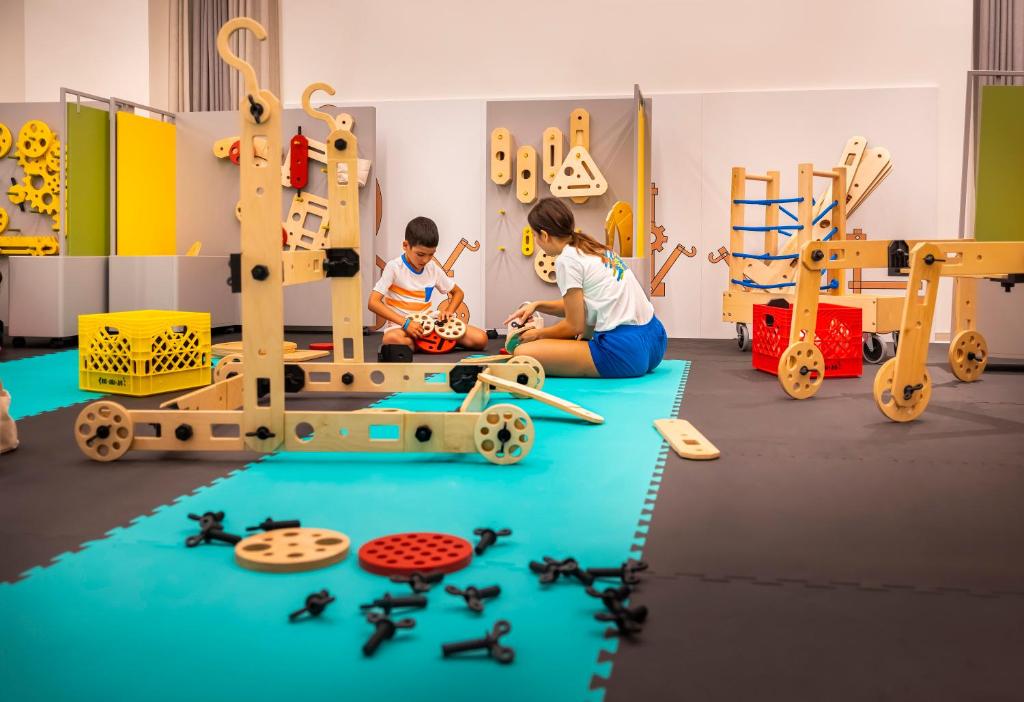 two children playing with toys in a play room at Valamar Diamant Hotel in Poreč