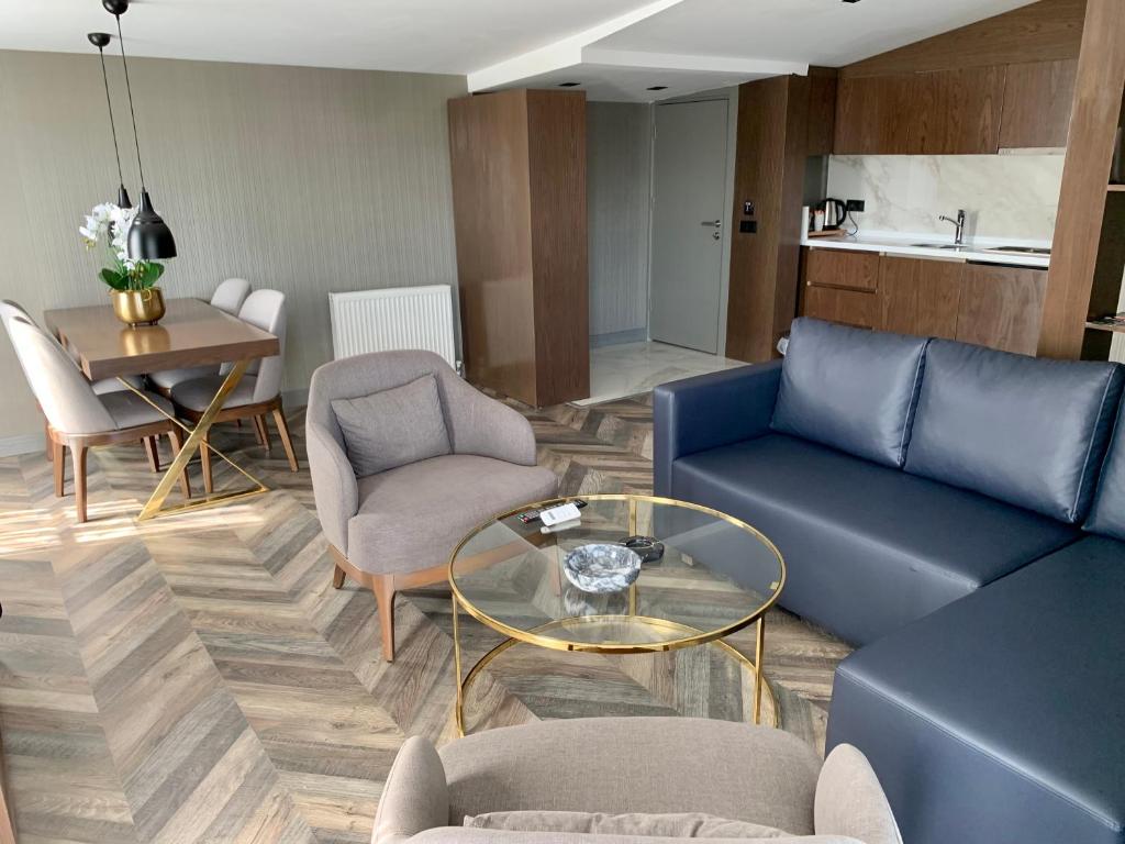 a living room with a blue couch and chairs and a table at Istanbul Park Hotel in Tuzla
