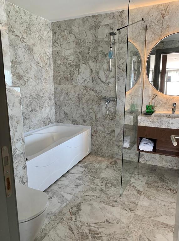 a bathroom with a tub and a toilet and a sink at Istanbul Park Hotel in Tuzla