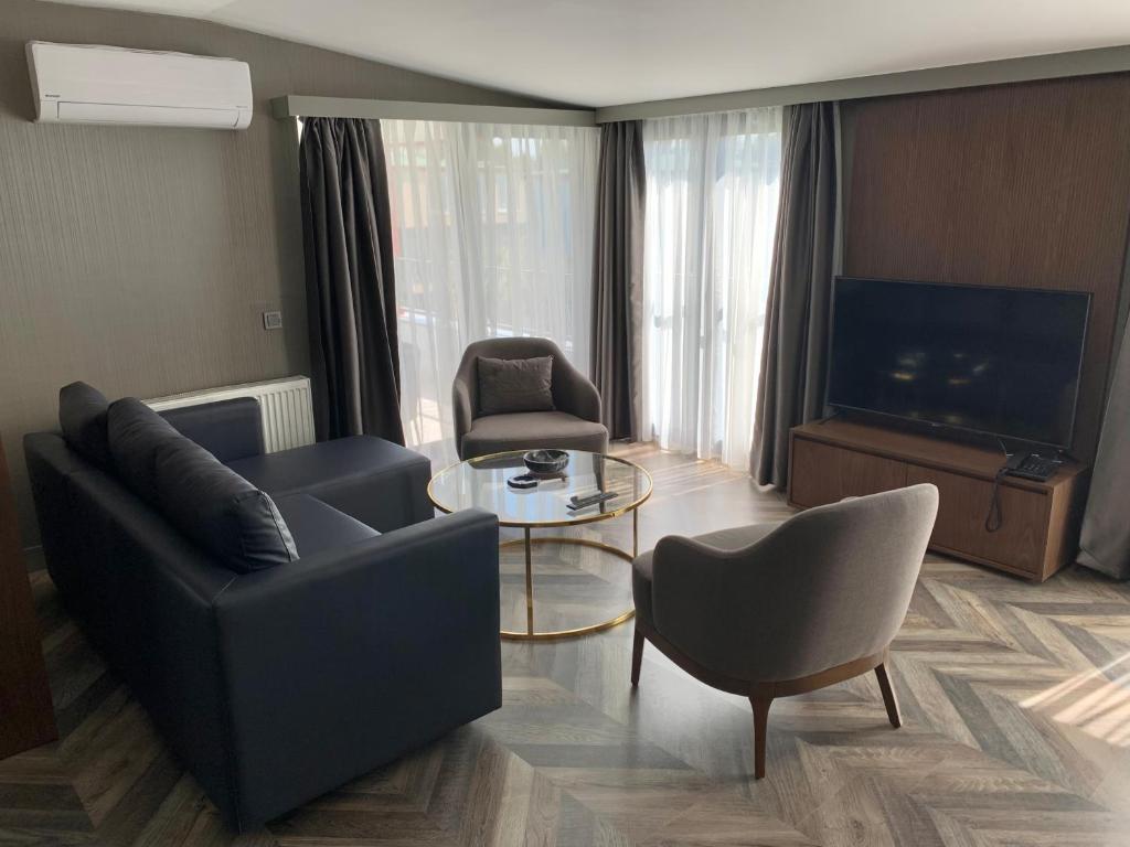 a living room with a couch and chairs and a television at Istanbul Park Hotel in Tuzla