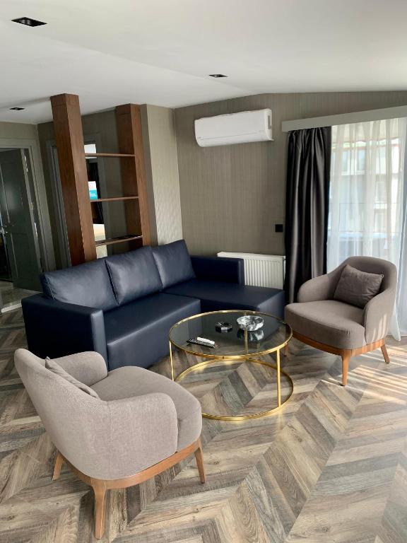 a living room with a blue couch and two chairs and a table at Istanbul Park Hotel in Tuzla
