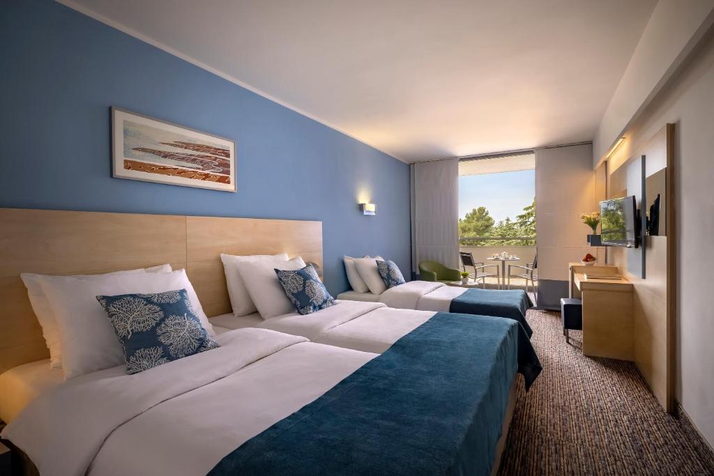 a hotel room with two beds and a balcony at Valamar Diamant Hotel in Poreč