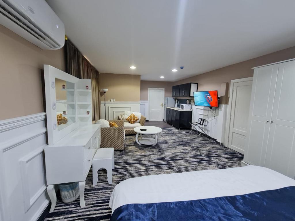 Habitación de hotel con 2 camas y sala de estar. en دار اوتيل Dar Otel, en Arar