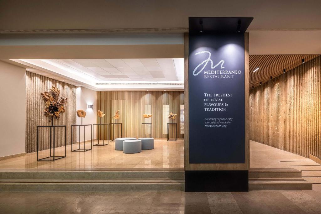 a lobby with a sign in the middle of a building at Valamar Diamant Hotel in Poreč