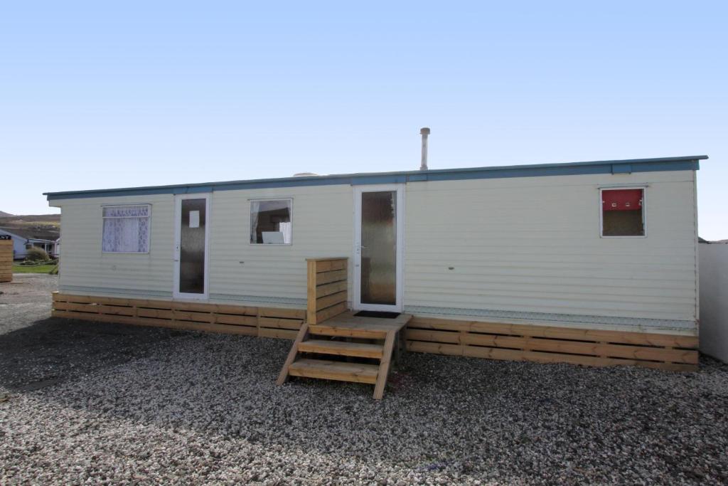 een kleine witte trailer met een ladder ernaast bij Skye Holiday Chalets C1 in Uig