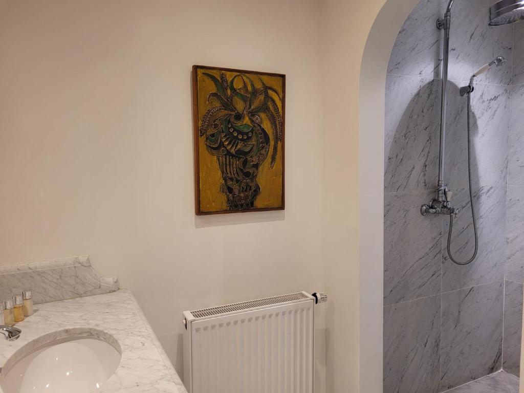 a bathroom with a sink and a shower with a picture at Molenmeers Boutique Guesthouses in Bruges