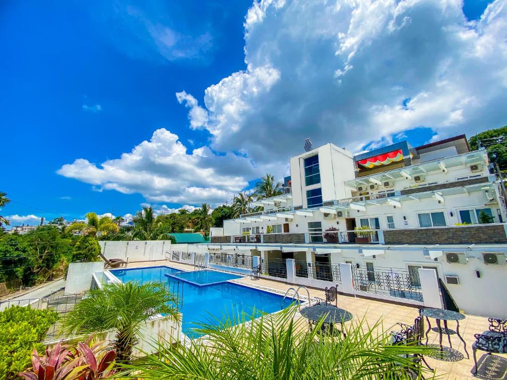 a hotel with a swimming pool in front of a building at Tagaytay Hotel SixB in Tagaytay