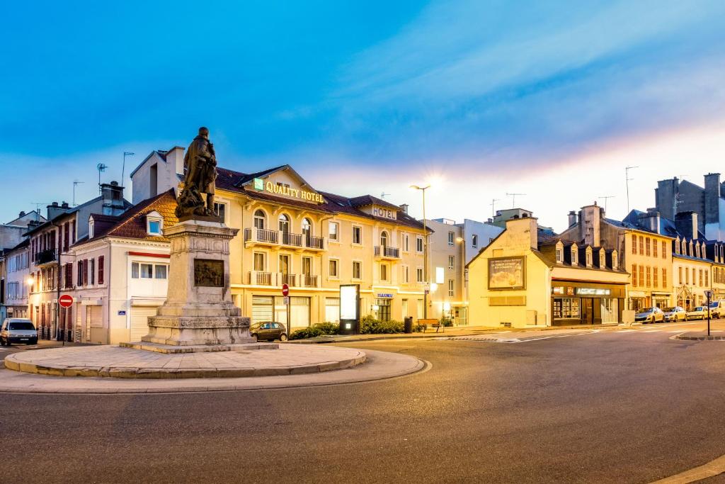 Une statue au milieu d'une rue avec des bâtiments dans l'établissement Quality Hotel Pau Centre Bosquet, à Pau