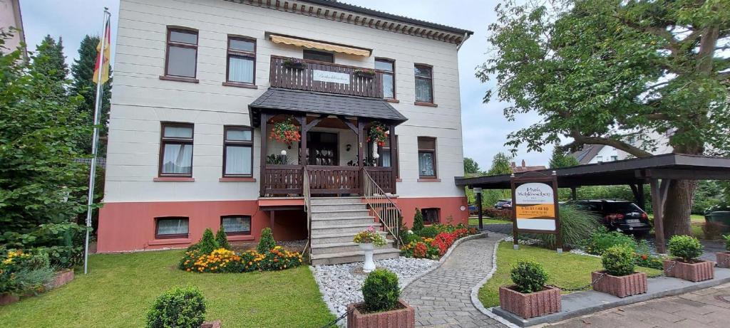 a white house with a porch and a balcony at Ferienwohnungen Parkschlösschen in Bad Pyrmont