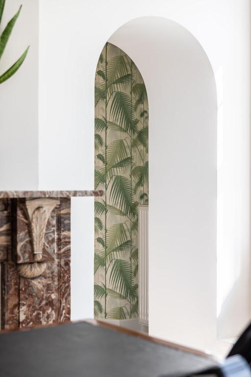 a dining room with a table and a mural of palm trees at Molenmeers Boutique Guesthouses in Bruges