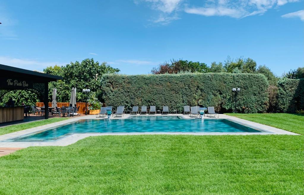 a swimming pool in the middle of a yard with chairs at Istanbul Park Hotel in Tuzla