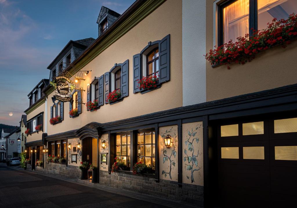 - un bâtiment avec des fenêtres et des boîtes de fleurs dans l'établissement Hotel Pistono, à Dieblich